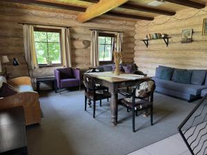 a living room with a table in a log cabin at Kaimo sodyba Dešimt Beržų in Gudžioniai