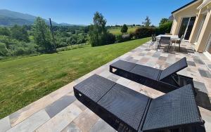 a patio with a table and chairs and a grill at Gite Gousseau in Buzy
