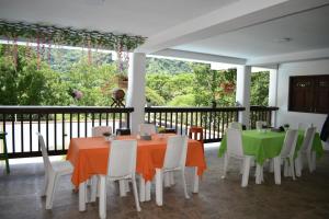 a dining room with tables and chairs on a balcony at hotel bocas del cauca in Tarso