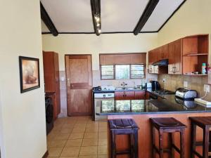 a kitchen with wooden cabinets and a counter top at Bush Willow Lodge in Hazyview