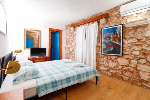 a bedroom with a bed and a stone wall at George's rooms in Stari Grad