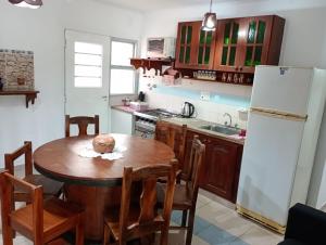 a kitchen with a wooden table and a white refrigerator at Finca las Azaleas in Posadas +12 photos