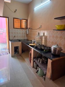 a kitchen with a counter with pots and pans on it at Jose Homestay in Madurai
