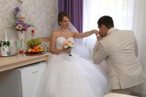 a bride and groom standing next to each other at Hotel Classic in Kirov