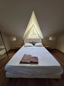 Un dormitorio con una cama grande con dos toallas encima. en Le Jardin des Sables avec piscine - 10 voyageurs, en Saint-Paul