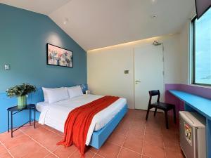a bedroom with a bed and a blue wall at Joi Home Beachfront in Vung Tau