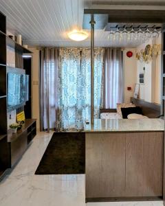 a living room with a kitchen with a counter and a couch at Cityloft Guesthouse in Tagbilaran City