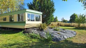 a tiny house on a rock in a yard at Au Domaine de la Vieille Dame in Cléré-du-Bois