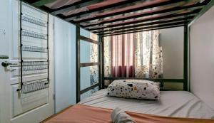 a small bedroom with a bed with a window at Cityloft Guesthouse in Tagbilaran City