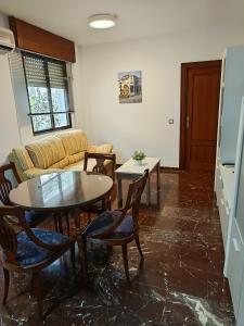 a living room with a table and chairs and a couch at Centro 3 - Pescadería in Jaén