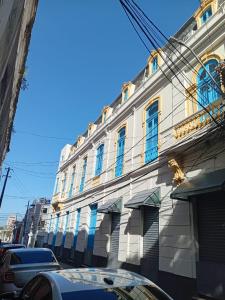 un bâtiment avec des fenêtres bleues sur une rue de la ville dans l'établissement General Hostel Belém, à Belém