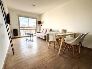 a living room with a couch and a table and chairs at deptoquedateaqui in Olavarría
