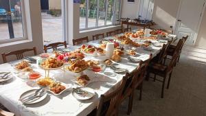 a long table with plates of food on it at Meerim Guest House in Bokonbayevo +16 photos