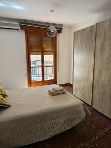 a bedroom with a large bed and a window at Centro 3 - Pescadería in Jaén