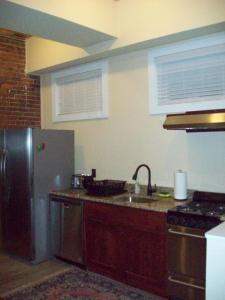 a kitchen with a stainless steel refrigerator and a sink at Large Historic Downtown Loft - Rear in Macon