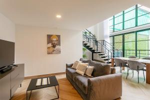 a living room with a couch and a table at Casco Viejo 2BR Loft - Rooftop Pool Gym & Balcony in Panama City