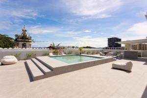 a patio with a swimming pool on top of a building at Casco Viejo 2BR Loft - Rooftop Pool Gym & Balcony in Panama City