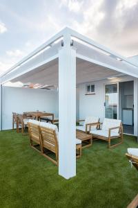 Una pérgola blanca en un patio con césped. en Profithome - Vista al Mar Ático Checha, en Candelaria