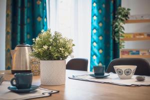 a table with two cups and a vase on it at Zuara9Room Rimini in Rimini