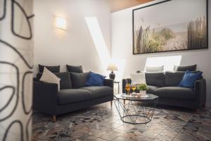 a living room with two couches and a table at Zuara9Room Rimini in Rimini