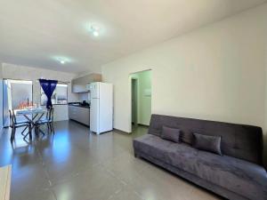 een woonkamer met een bank en een keuken bij Casa 02 com 2 quartos, churrasqueira 15min centro in Foz do Iguaçu +29 foto's