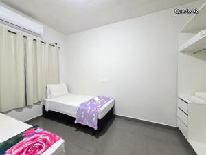 een kleine kamer met 2 bedden en een kast bij Casa 02 com 2 quartos, churrasqueira 15min centro in Foz do Iguaçu