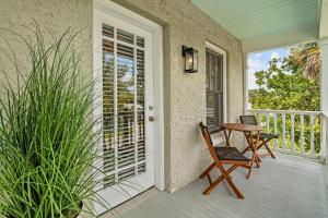 a porch with a table and chairs on a balcony at Casita Tropical l Walk to DT l Mins to Beach in Saint Augustine