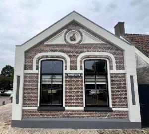 沃尔克姆It HavenNêst的砖砌的建筑,有两扇窗户,上面有时钟