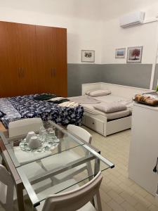 a room with two beds and a glass table and chairs at Residence Della Corte in Tocco da Casauria