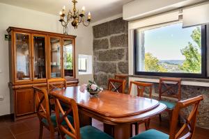 a dining room with a wooden table and chairs at Leira da Cruz Grande in Castelo de Paiva