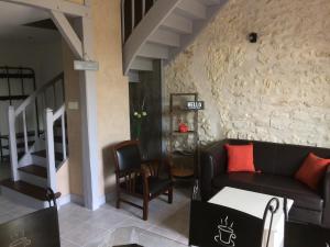 a living room with a couch and a stair case at Gite Les petits balcons in Pocé-sur-Cisse