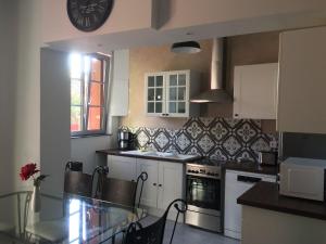 a kitchen with a table and a clock on the wall at Gite Les petits balcons in Pocé-sur-Cisse