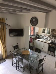 a table and chairs in a kitchen with a clock on the wall at Gite Les petits balcons in Pocé-sur-Cisse