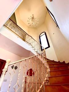 een trap in een huis met een kroonluchter bij Villa Santa Bárbara en Isla Canela in Isla Canela