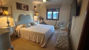 een slaapkamer met een bed en een televisie. bij Villa Santa Bárbara en Isla Canela in Isla Canela +17 foto's