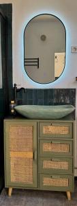 a bathroom with a sink and a mirror on a dresser at Villa Kastrouna, with private heated jacuzzi in Symi