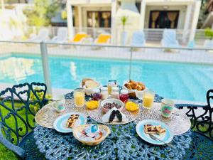 a table with food and drinks on it next to a pool at Nereidas Apart in Mar de las Pampas