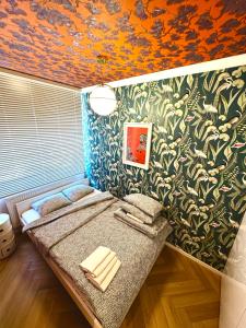 Habitación con cama y pared con plantas. en Piltza House, en Cracovia 6 fotos más