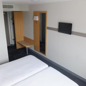 a room with a bed and a mirror at B&B HOTEL La Rochelle Centre in La Rochelle