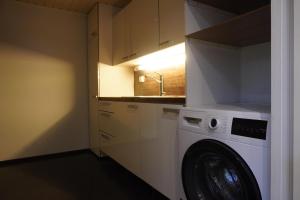 a laundry room with a washer and a sink at Near Santa Village with Free Parking in Rovaniemi