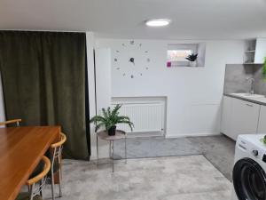 a kitchen with a table and a clock on the wall at Apartmán Zobor in Nitra