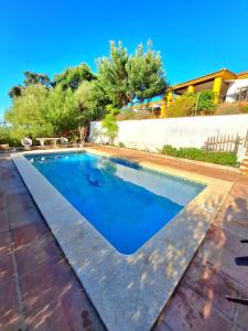 a swimming pool with blue water in a backyard at La Cabaña de la Cigarra in Almodóvar del Río