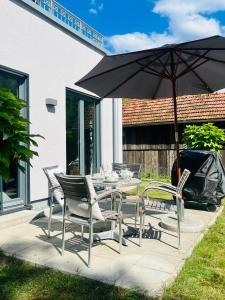 a table and chairs with an umbrella on a patio at Apartment im Grünen mit Stil in Mitterfels
