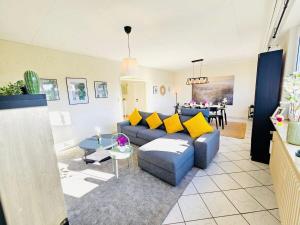 a living room with a blue couch and yellow pillows at Chic Urban Stay 2BR with parking- BEL4 in Luxembourg