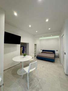 a bedroom with a bed and a white table and chairs at Kupe Luxury Loft in SantʼAgata sui Due Golfi +8 photos