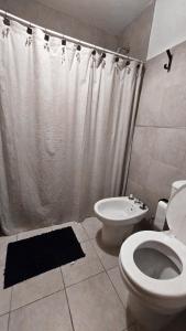 Un baño con inodoro, ducha y lavabo. en CHACABUCO 1 dormitorio, en Córdoba 5 fotos más