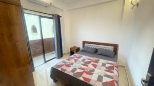 a bedroom with a bed and a large window at SA properties in Kalubowila West