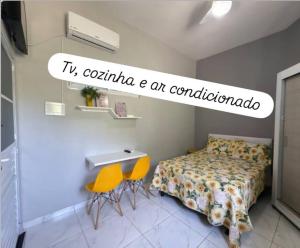 a bedroom with a bed and two yellow chairs at Nº 01 Mini Apart 5 min Centro cozinha e garagem in Divinópolis