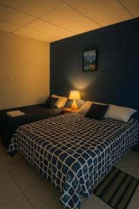 a bedroom with a large bed with a blue wall at Blue Lion Lodge in Juayúa