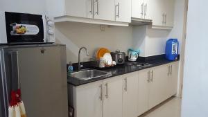a small kitchen with a sink and a microwave at CNholy Condo at SEA Residences in Manila